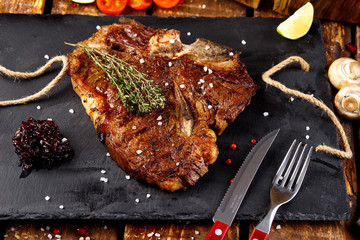 Grilled T-bone barbecue steak with fresh rosemary on a chopping Board