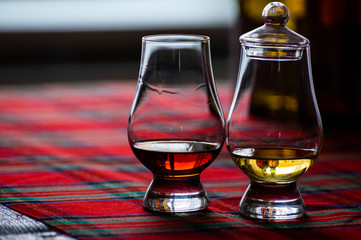 Special tulip-shaped glass for tasting of Scotch whisky on distillery in Scotland, UK and red tartan
