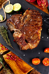 Grilled T-bone barbecue steak with fresh rosemary on a chopping Board