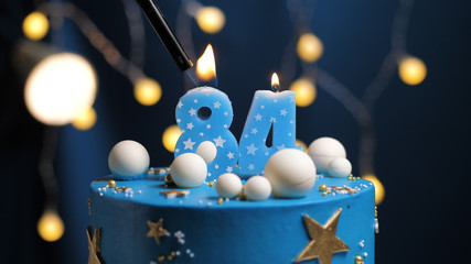 Birthday cake number 84 stars sky and moon concept, blue candle is fire by lighter. Copy space on...
