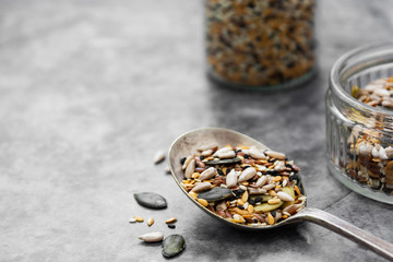 Healthy seeds mix in a wooden spoon close up. Healthy foods, vegan food ingredient.