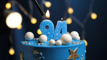 Birthday cake number 94 stars sky and moon concept, blue candle is fire by lighter. Copy space on...
