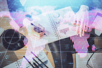 International business hologram over hands taking notes background. Concept of success. Multi exposure