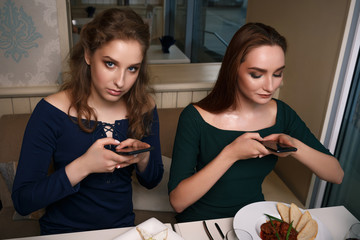 Beautiful girl is making photo of food in cafe, latte on the table pizza, communication in social networks