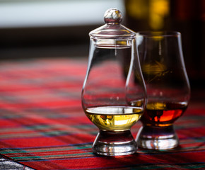 Special tulip-shaped glass for tasting of Scotch whisky on distillery in Scotland, UK and red tartan