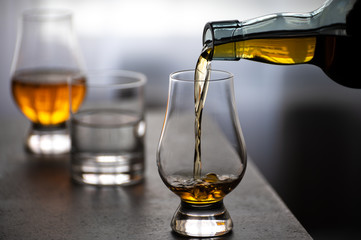 Pouring in tulip-shaped tasting glass Scotch single malt or blended whisky