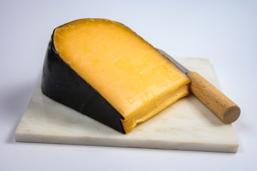 One piece of old Dutch gouda cheese with black wax
