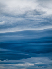 Blue lenticular clouds form in the sky at evening