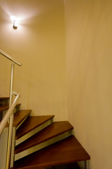 Interior spiraling staircase lit with small wall mounted light