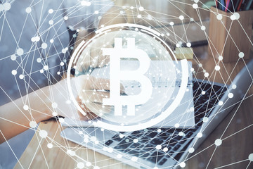 Cryptocurrency hologram, bitcoin, ico theme over hands taking notes background. Concept of blockchain. Multi exposure