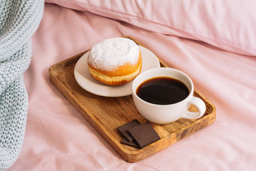 Morning breakfast in bed with fresh and hot coffee, a doughnut in powdered sugar and three slices...
