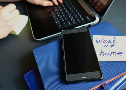 ayout of a laptop, pen, notebook on the surface for remote work