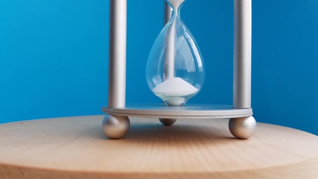 Elegant hourglass on a blue background. Concept-business time money, education, time is running out, time management, time resource, fulltime, deadline