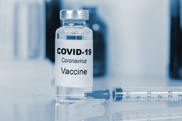 Coronavirus vaccine - The medical concept. Ampoule and syringe. Copyspace. blue toning.