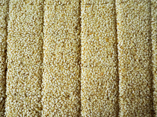 White sesame seeds with honey and sugar on parchment paper in the process of making gluten-free cookies