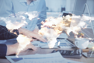 Double exposure of businessman working on laptop on background. International business hologram in front. Concept of success.