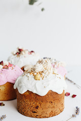 Glazed easter cake decorated with flowers on white textured background. Happy Easter Holidays