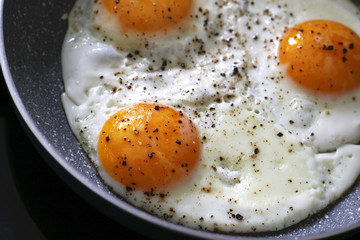 three baked eggs in frying pan
