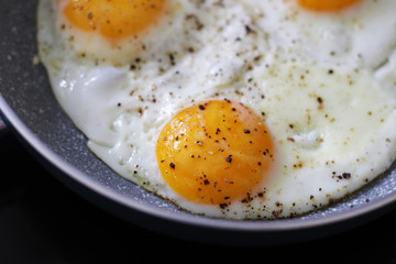 three baked eggs in frying pan