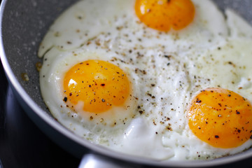 three baked eggs in frying pan