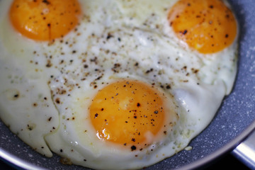 three baked eggs in frying pan