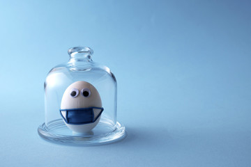 Coronavirus, COVID-19, self-quarantine, isolation, social disdancing concept. Stay home, stay safe  Eggs wearing medical mask for stop coronavirus a on blue background