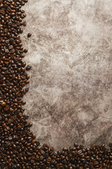 coffee beans on the background of the cracked cement table texture in the view from above with copy space Idea for menu in the coffee shop or cafe drink menu