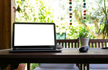 Photography of a laptop with a screen template for advertising, with a garden in the background. Telecommuting picture from home.