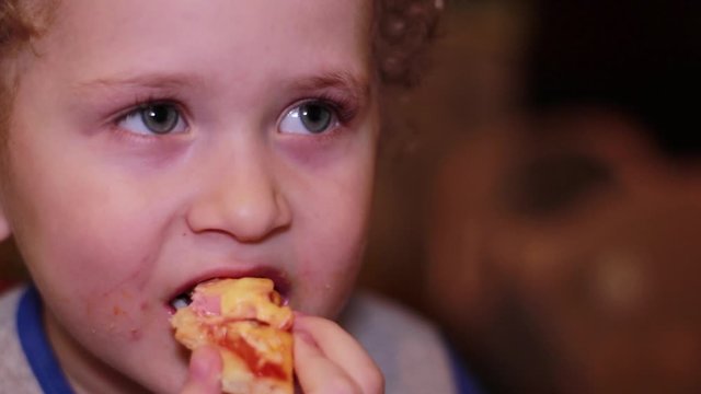 Little boy eats pizza. Portrait, close-up, slow-motion video