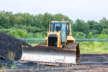 Bulldozer dredges rubble on road construction