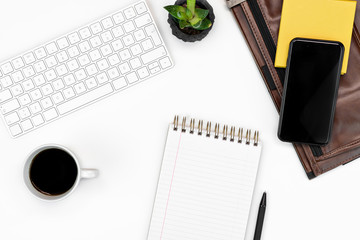 flat-lay of White office table layout. keyboard, glasses, phone, notebook and laptop case. copy space layout