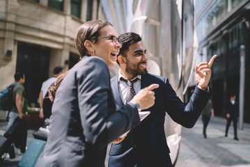 Happy elegant worker having fun with colleague in street