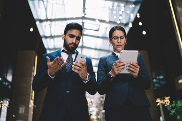 Serious ethnic clerks solving problem with gadgets