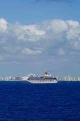 Huge modern Costa Cruises cruiseship or cruise ship liner Costa Favolosa at sea with skyline of...