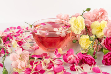 Pink Flower Tea with Carnation Petals. Hot Rose Drink in Glass Cup