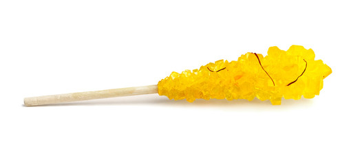 Aromatic crystallized sugar with saffron threads on a wooden stick isolated on white background.
