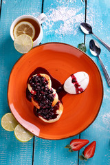 Cottage cheese pancakes with currant on a plate