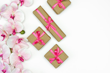 flat-lay of Gift present boxes with pink ribbon with orchid flowers on white background. spring concept. Copy space