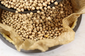 Adding baking beans into pastry case