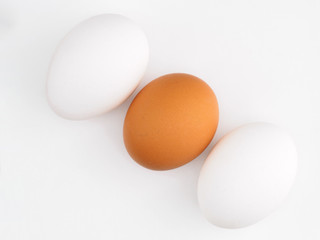 Three white and brown eggs on a white background. Healthy eating concept