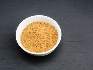 Spice masala powder in white ceramic bowl on black wooden background. Healthy eating and organic food concept