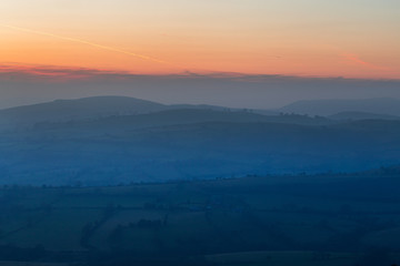 Red Clouds over Hazy Countryside Fields