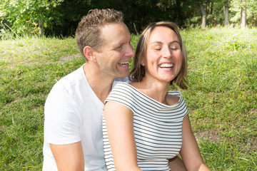 Happy laughing lovely young couple in love spending time outdoors summer day