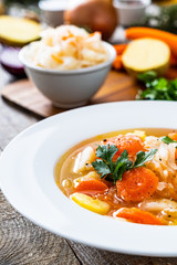 Bowl of hot cabbage soup on wooden table