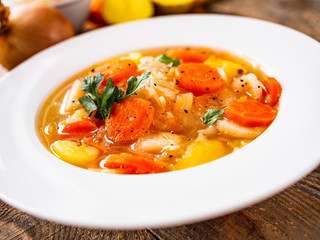 Bowl of hot cabbage soup on wooden table