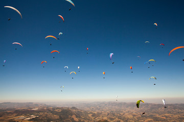 many paragliders flying together at beautiful sunny day