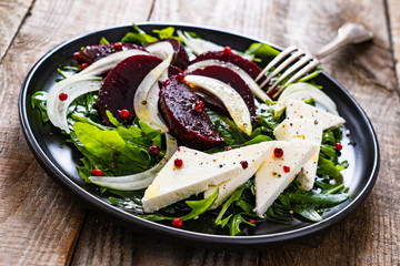  Beetroot salad with feta cheese on wooden background
