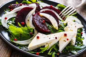  Beetroot salad with feta cheese on wooden background
