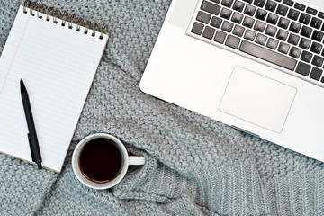 Flat-lay of Cosy working writing place with warm sweater coffee, note paper and phone. work from home. Writing. 