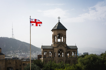 Bell Tower with georgian flag near Holy Trinity Cathedral of Tbilisi also known as Tsminda Sameba, Georgia